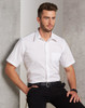 A white short sleeve button-up shirt with a pocket, featuring a logo, worn by a model against a textured background.