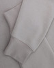 A light grey crewneck sweatshirt with a soft texture, featuring long sleeves and a cuffed hem.