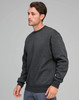 A man wearing a dark grey crew fleece sweatshirt, featuring a relaxed fit and ribbed cuffs.