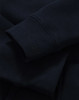 A close-up of a navy full-zip fleecy hoodie showcasing the cuffs and fabric texture. It has a logo.