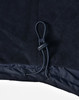 A close-up of a navy unisex jacket featuring a drawstring at the hem and a smooth fabric texture.