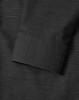 A black pin dot stretch long-sleeve shirt featuring a buttoned cuff and a subtle pattern, with a logo present.
