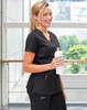 Black ladies' scrub top with a V-neck and pockets, held by a smiling woman holding a white drink bottle.