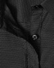 A close-up of a black ladies' button-up shirt with a pin dot pattern and a visible button.