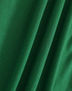 A close-up of soft, textured green fabric, showcasing folds and depth suitable for polo shirts.