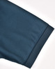A close-up of a dark teal polo shirt sleeve, featuring a smooth texture and a hemmed cuff.