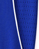 A close-up of a blue polo shirt featuring contrasting fabric textures and a white trim. It has a logo on the garment.