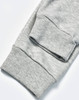 A pair of grey poly/cotton terry sweat pants with ribbed cuffs. The image highlights the fabric texture.