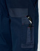 A close-up of navy blue work pants featuring multiple pockets, including a pen pocket, with visible stitching details.