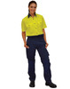A woman wears bright yellow short-sleeve shirt and navy work pants, with a logo visible on the shirt.