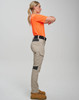 Work pants in beige with black accents, styled on a model wearing an orange top, showcasing a side view.