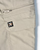 A close-up of light khaki work pants featuring a zippered pocket and a small logo on the side.