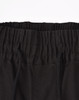 A close-up of unisex cotton stretch drill cuffed work pants in black, featuring an elastic waistband and drawstring.