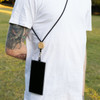 A phone lanyard featuring a black strap and wooden bead, securely holding a smartphone on a person's back.
