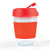 A reusable coffee cup with a clear body and a bright red flip lid, featuring a matching silicone sleeve for grip.