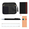 A black zippered pouch, a black notebook with a red accent, a silver pen, a colorful marker set, and a white ruler.