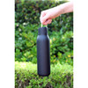 A drink bottle in matte black with a metal loop, designed for easy carrying. It has a sleek, minimalist appearance.