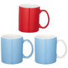 A set of three ceramic mugs in red, blue, and white, each with a handle and a glossy finish. One mug has a logo.