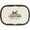 A cream lunch box with a black lid and an embossed logo featuring a cow and text branding.
