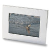 A nickel plated photo frame showcasing a beach scene with a child playing by the water.