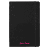 A black journal with an elastic band, featuring a custom name in pink text at the bottom. It includes a branding logo.