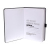 An A5 notebook with a black cover, featuring white recycled paper pages and a logo.