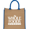 A large beige jute tote bag with blue handles and a logo on the front.