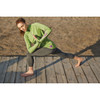 A woman in a green Taza Knit Quarter Zip jumper and grey leggings performs a lunge on a wooden surface.