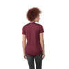 A woman wearing a short sleeve tech tee in burgundy, viewed from the back, featuring a logo.