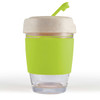 A reusable coffee cup with a clear glass base, a green silicone band, and a speckled lid with a straw.