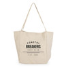 A cream tote bag with a logo featuring the text "Coastal Breakers Surf Club" and a date.