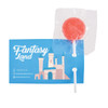 A red lollipop with a white stick, packaged with a colorful card featuring a castle and branding.