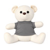 A plush bear with a creamy white body and a grey shirt, featuring large black eyes and a friendly expression.