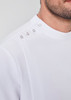 A close-up of a white jacket featuring a high neck and decorative snap details on the shoulder, with a logo.