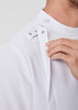 A white jacket featuring snap fasteners and a zip opening, with a close-up view of the collar area.