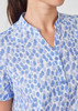 A blue and white tunic featuring a stardust print, with a collared neckline and button details.