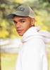 A breathable grey poly twill cap with honeycomb mesh, featured on a model wearing a white hoodie.