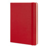 A large red Moleskine classic hard cover notebook with an elastic closure and blank pages.