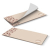 A horizontal note pad with 25 leaves, featuring a beige design with floral and coffee bean illustrations. It has a logo.