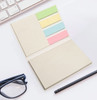 A sticky note booklet with beige covers and colourful sticky notes in green, yellow, blue, and pink.