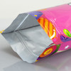 A medium-sized foil stand-up pouch in vibrant pink with colourful graphics and a silver interior.