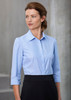 A light blue women's button-up shirt with 3/4 sleeves, featuring a collar and a logo.