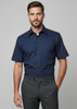 A navy short sleeve button-up shirt featuring a classic collar, worn with grey trousers. The shirt has a logo.