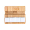 A bamboo stand featuring three white square stress reliever blocks on a smooth surface.