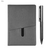 A grey notebook with a sleek textured finish and a silver metal pen beside it. The notebook features a pocket design.