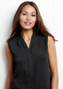 A sleeveless women's top in black, featuring a v-neck and a relaxed fit, displayed on a model against a light background.