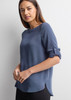 A women's boatneck top in a soft blue shade with rolled sleeves and a slight high-low hem. Features a logo.