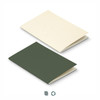 A soft cover notebook featuring a cream and dark green recycled paper design, with a logo visible on the surface.