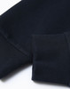 A close-up of a navy unisex crew neck sweater featuring ribbed cuffs and a smooth finish. Contains a logo.