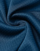 A close-up of a dark blue textured fabric, showcasing a sustainable jacquard knit design.